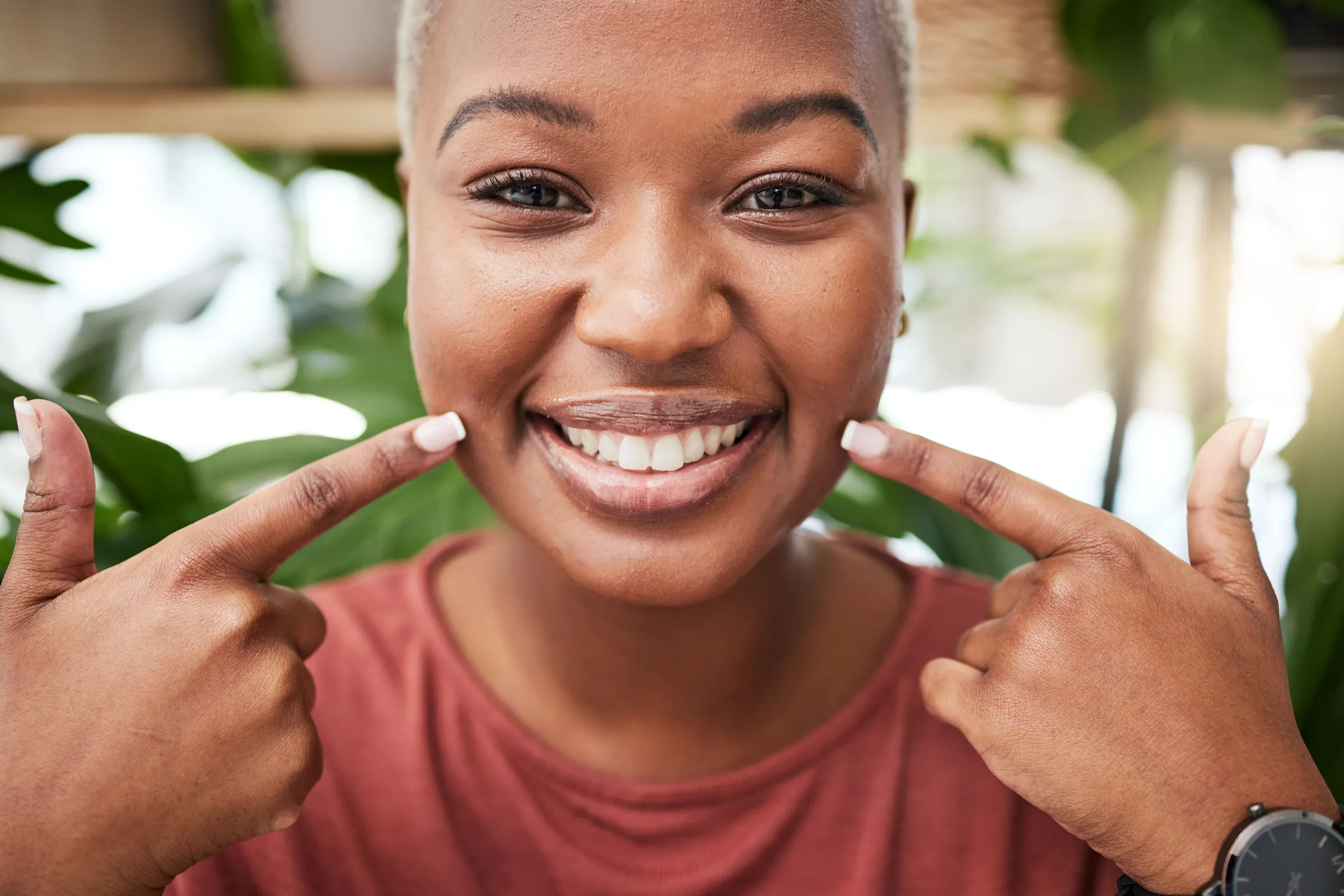 A smiling woman pointing to her teeth