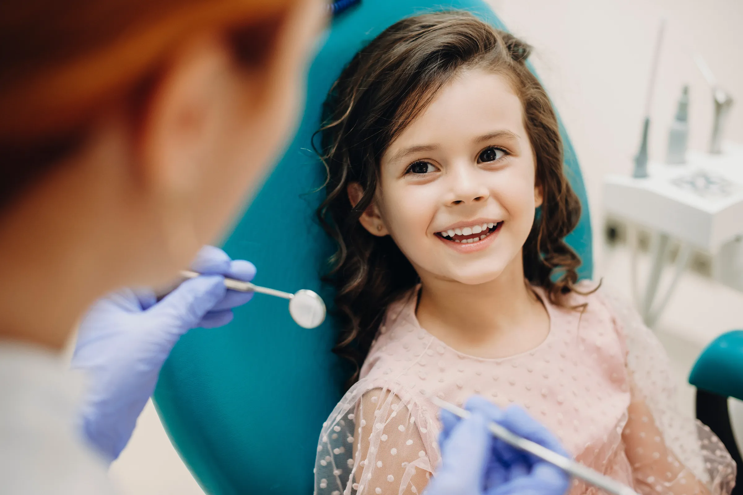 A smiling young girl in the dental chair during a checkup