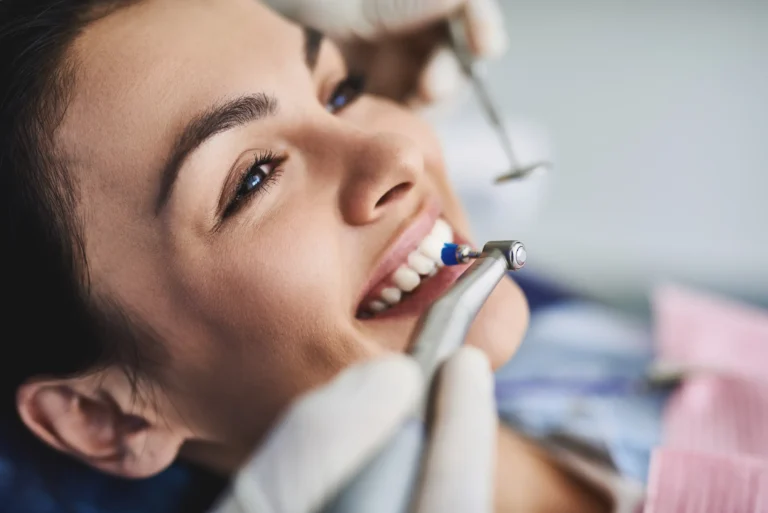 A smiling woman having her teeth cleaned in the dental chair