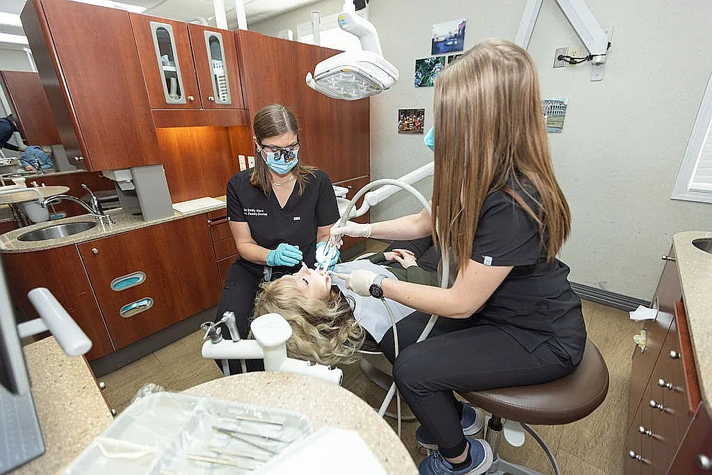 A dentist and hygienist treating a patient