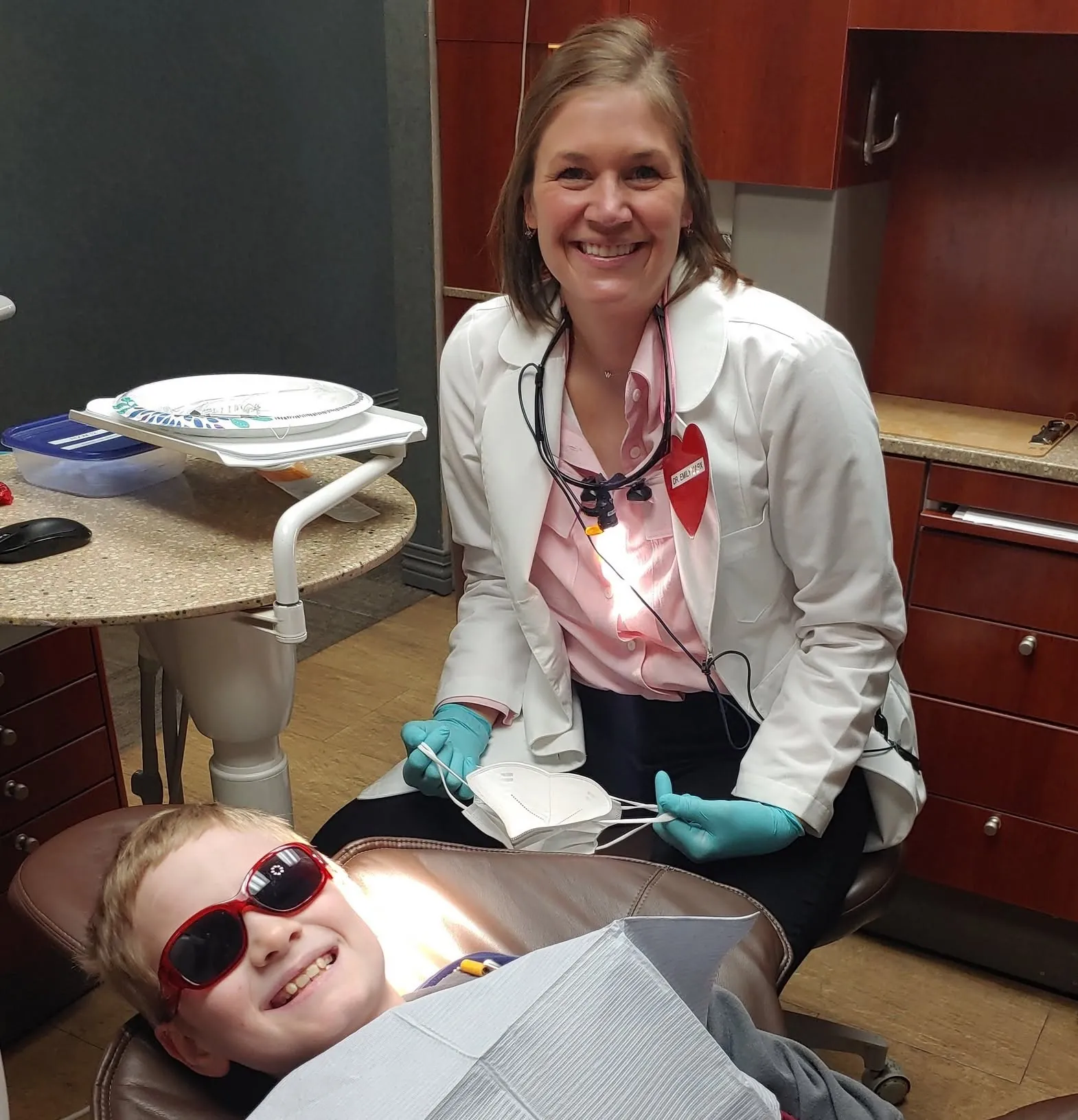 A dentist with a young patient in sunglasses on Have a Heart Day