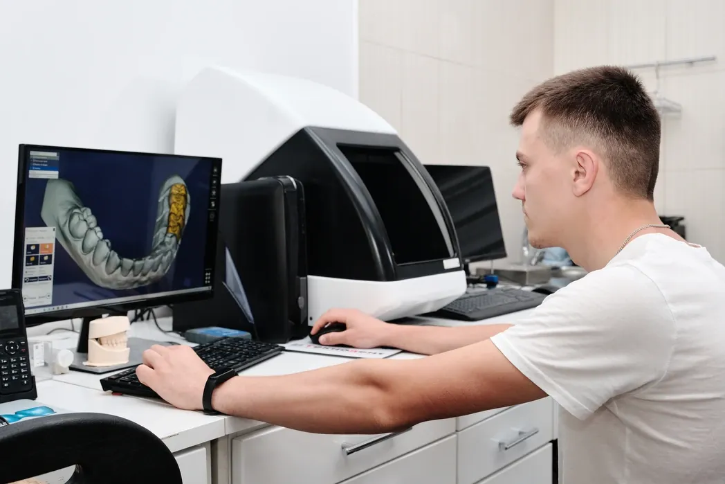 A technician designing a crown on a CAD screen