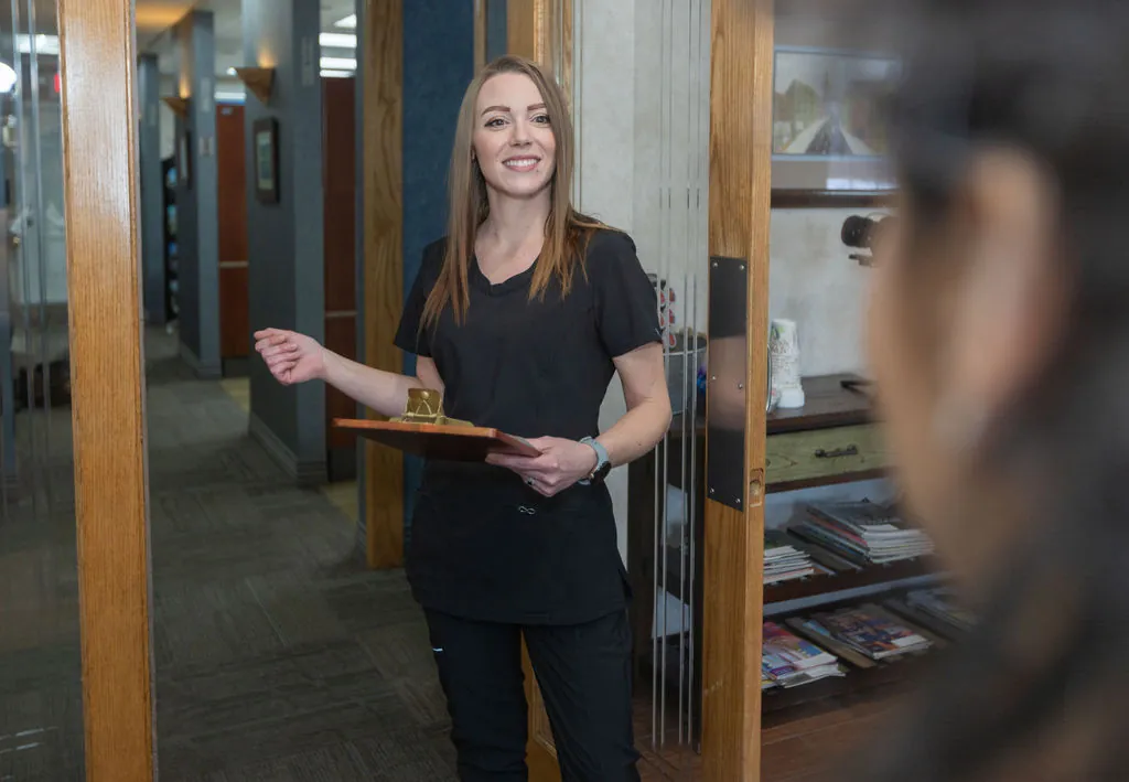 A team member welcoming patients in the hallway